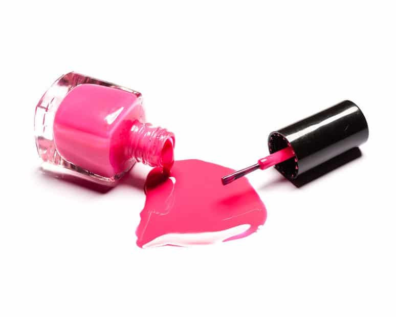 Pink nail polish and brush on white background