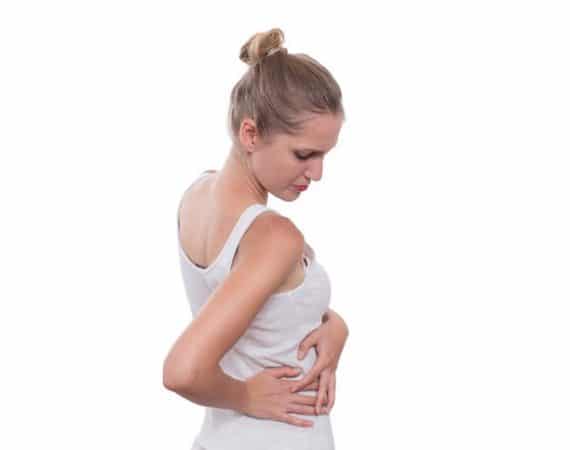 Young female touching right side of body in pain. Kidney pain. Isolated on white background